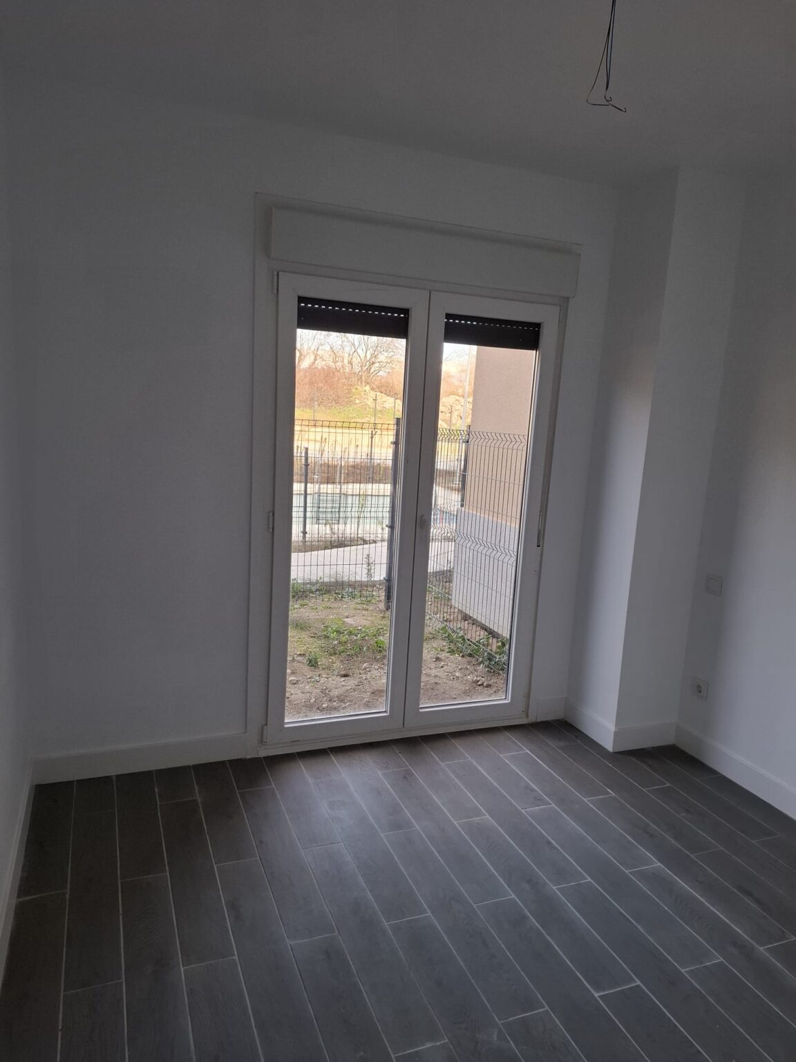 Estancia reformada con puertas acristaladas y acceso al jardín en vivienda de Madrid