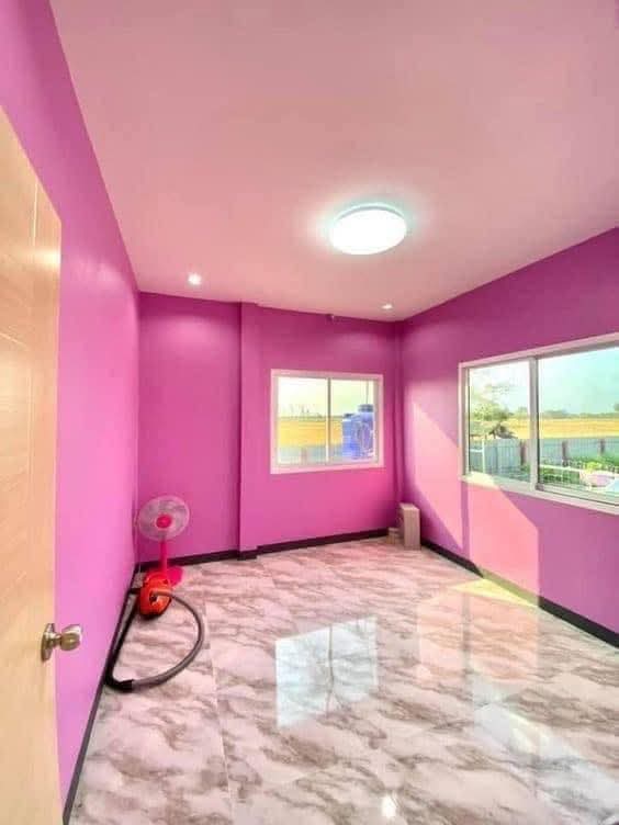 Habitación con paredes en color rosa tras trabajos de pintura en reforma de vivienda en Madrid