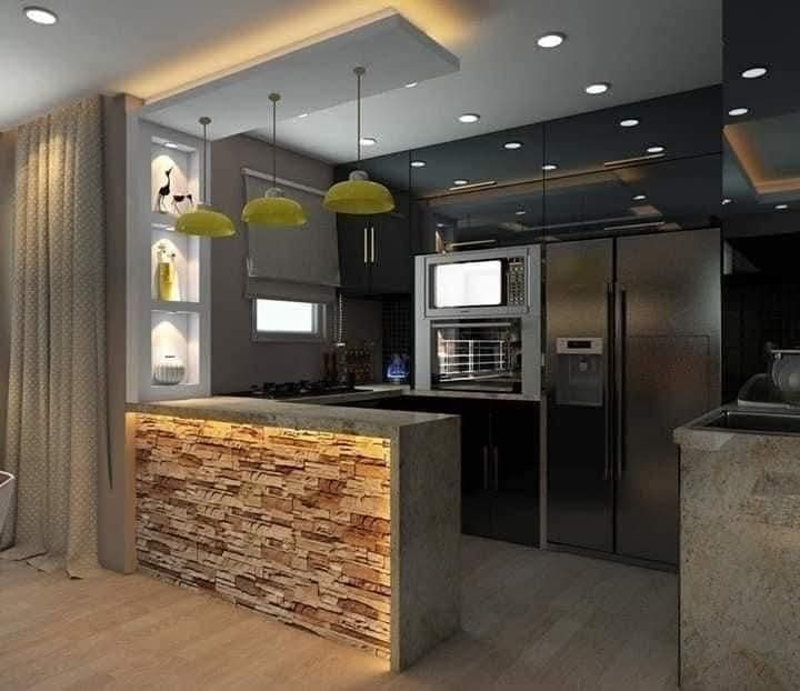 Cocina moderna con isla y iluminación decorativa tras reforma integral realizada en Madrid