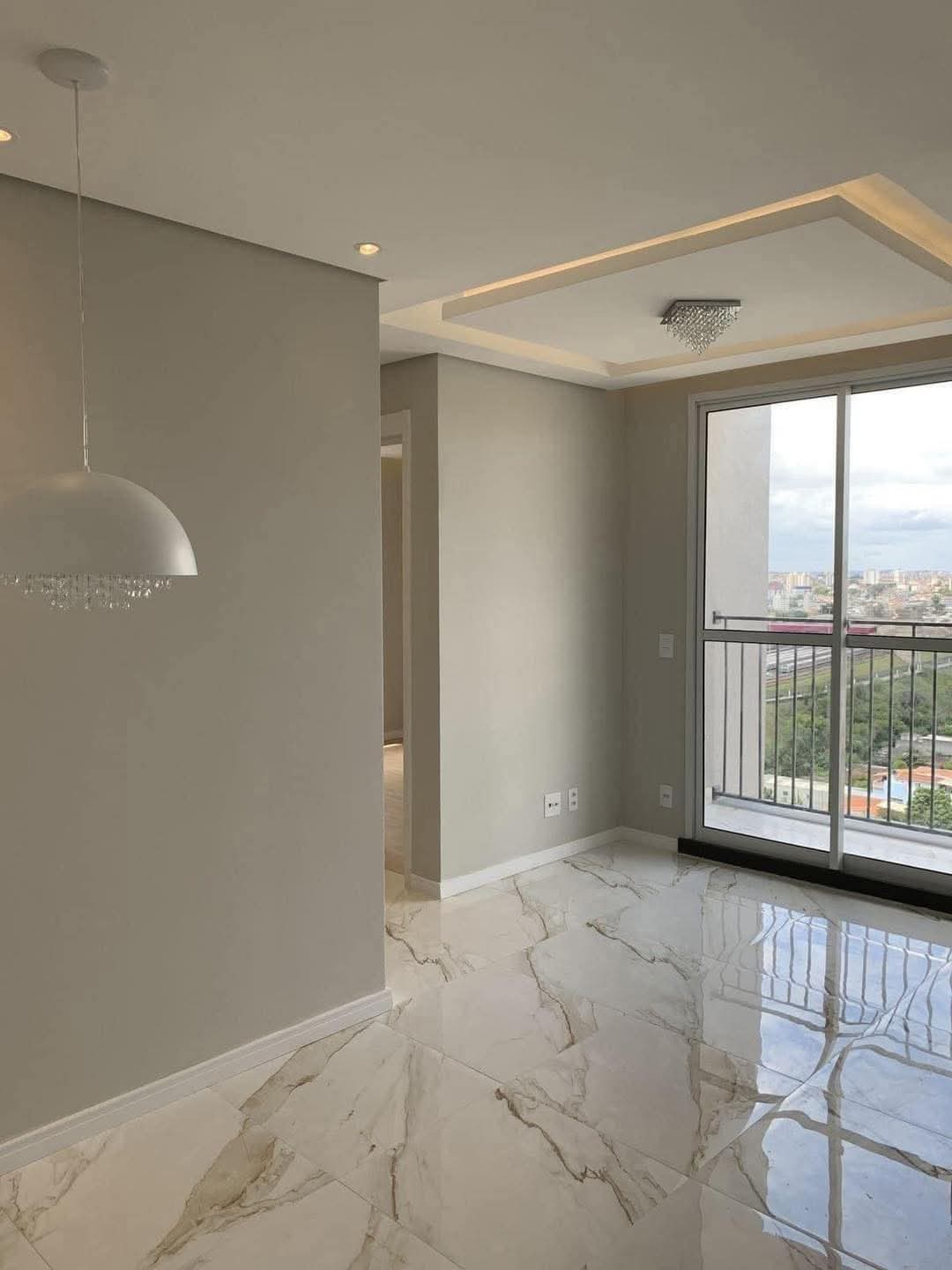 Salón moderno con iluminación indirecta y acceso a balcón tras reforma integral en Madrid