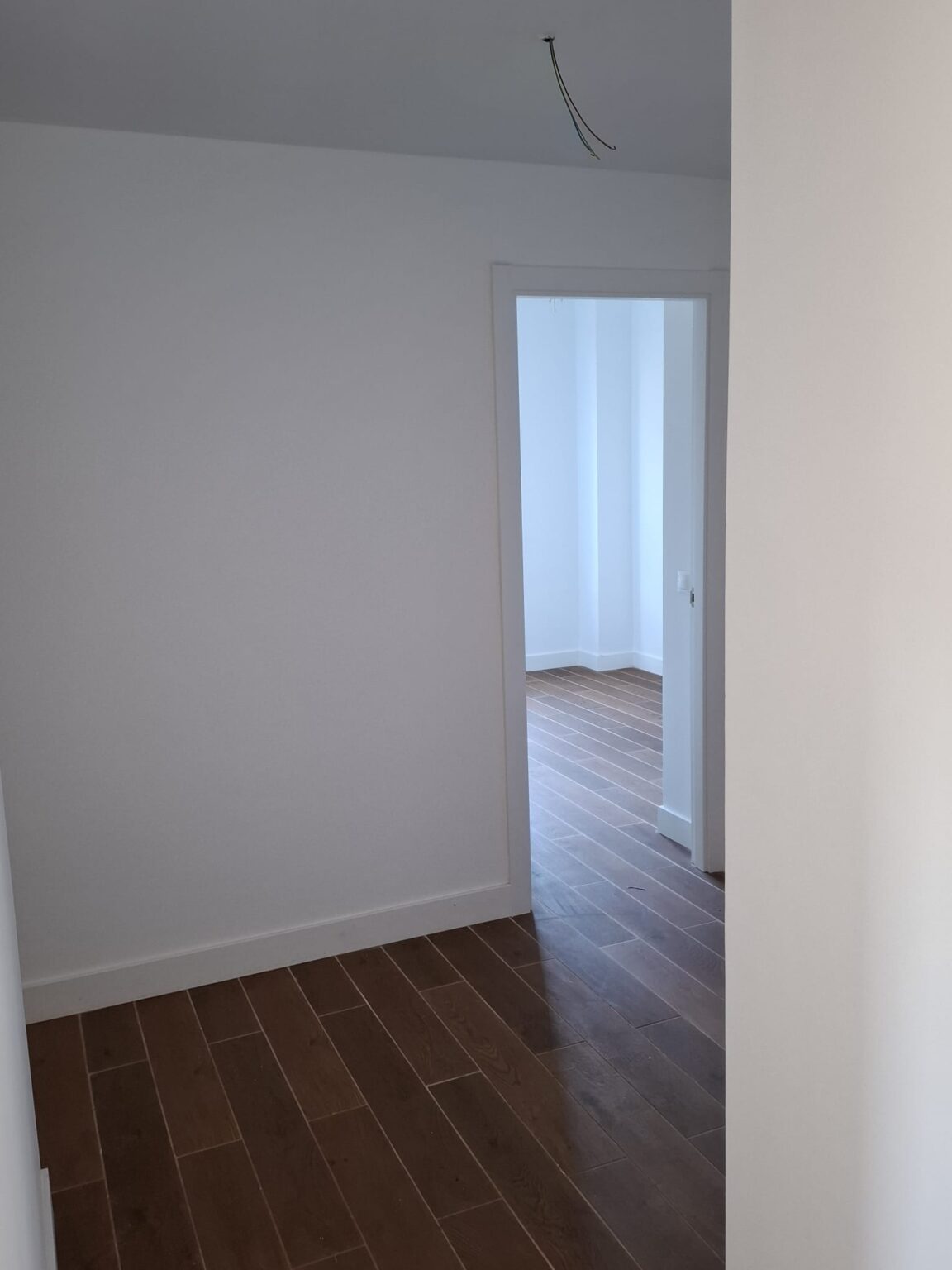 Pasillo con suelo de madera instalado durante reforma integral de vivienda en Madrid