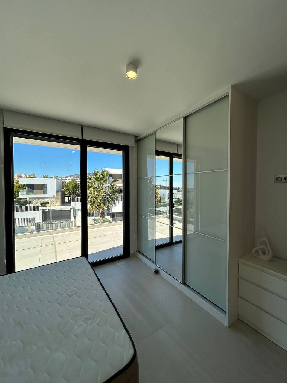 Espacio interior reformado con puertas de cristal y acceso a terraza en vivienda de Madrid