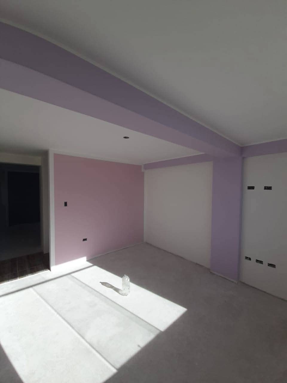 Salón reformado con paredes pintadas en tonos claros tras reforma integral en Madrid