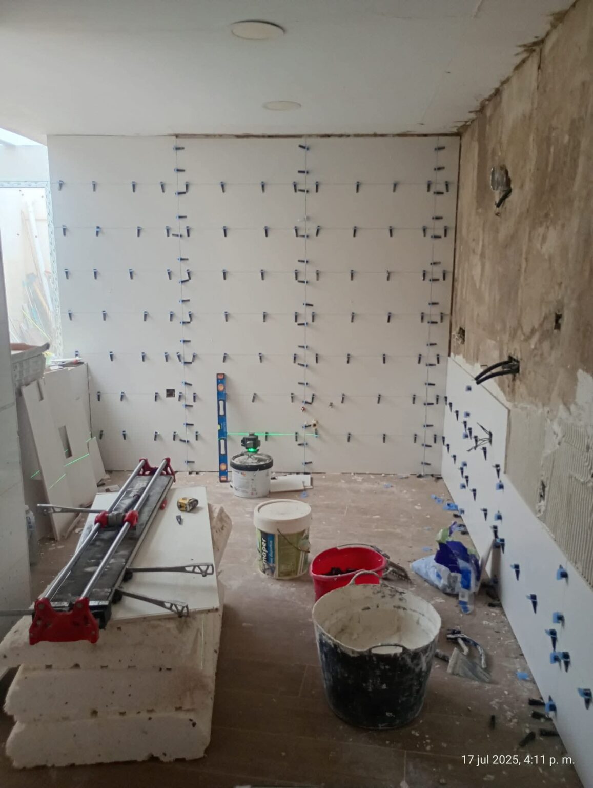 Cocina en proceso de reforma con instalación de azulejos y mobiliario en vivienda de Madrid
