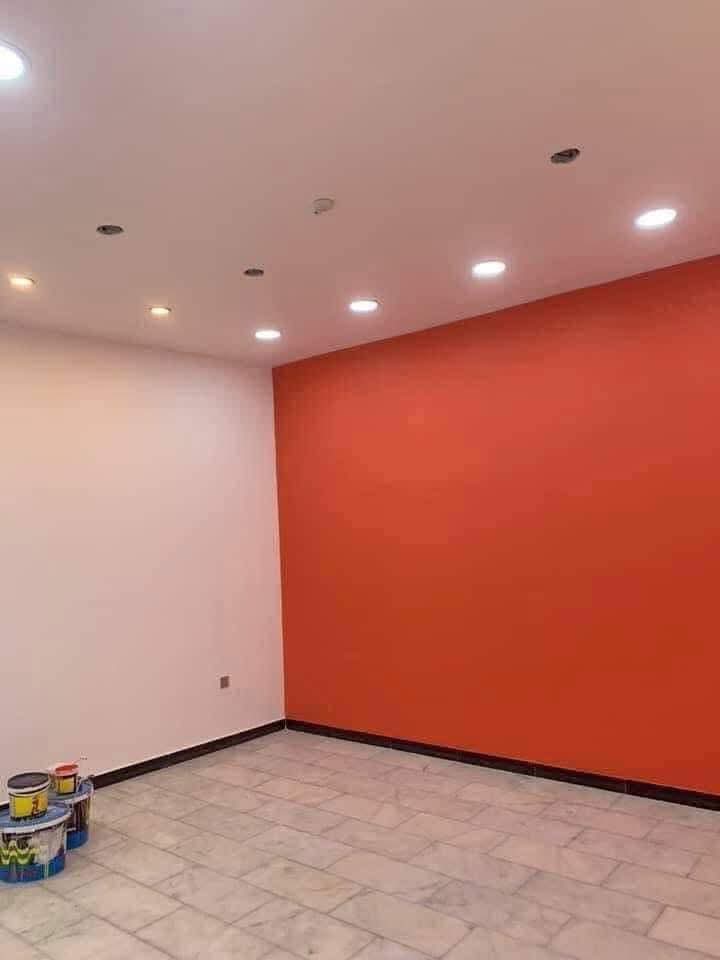 Habitación con iluminación empotrada y pared roja tras reforma integral en Madrid