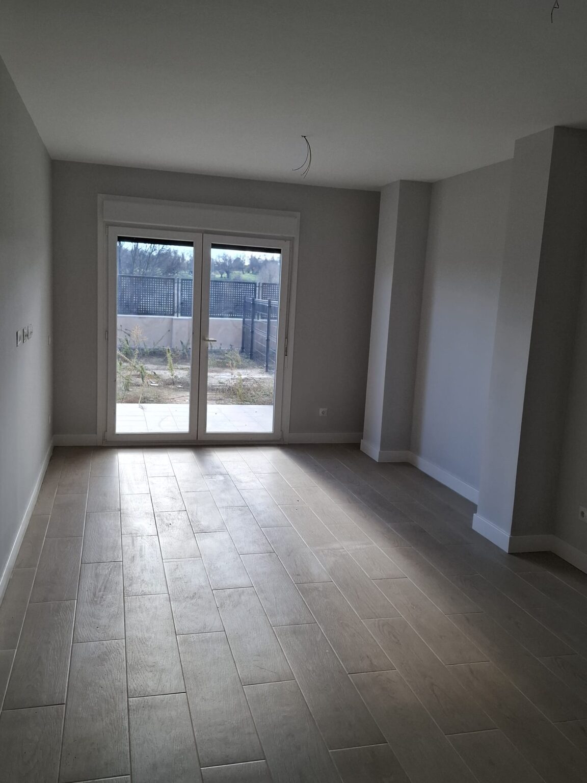 Salón luminoso con suelo porcelánico tras reforma integral en vivienda de Madrid