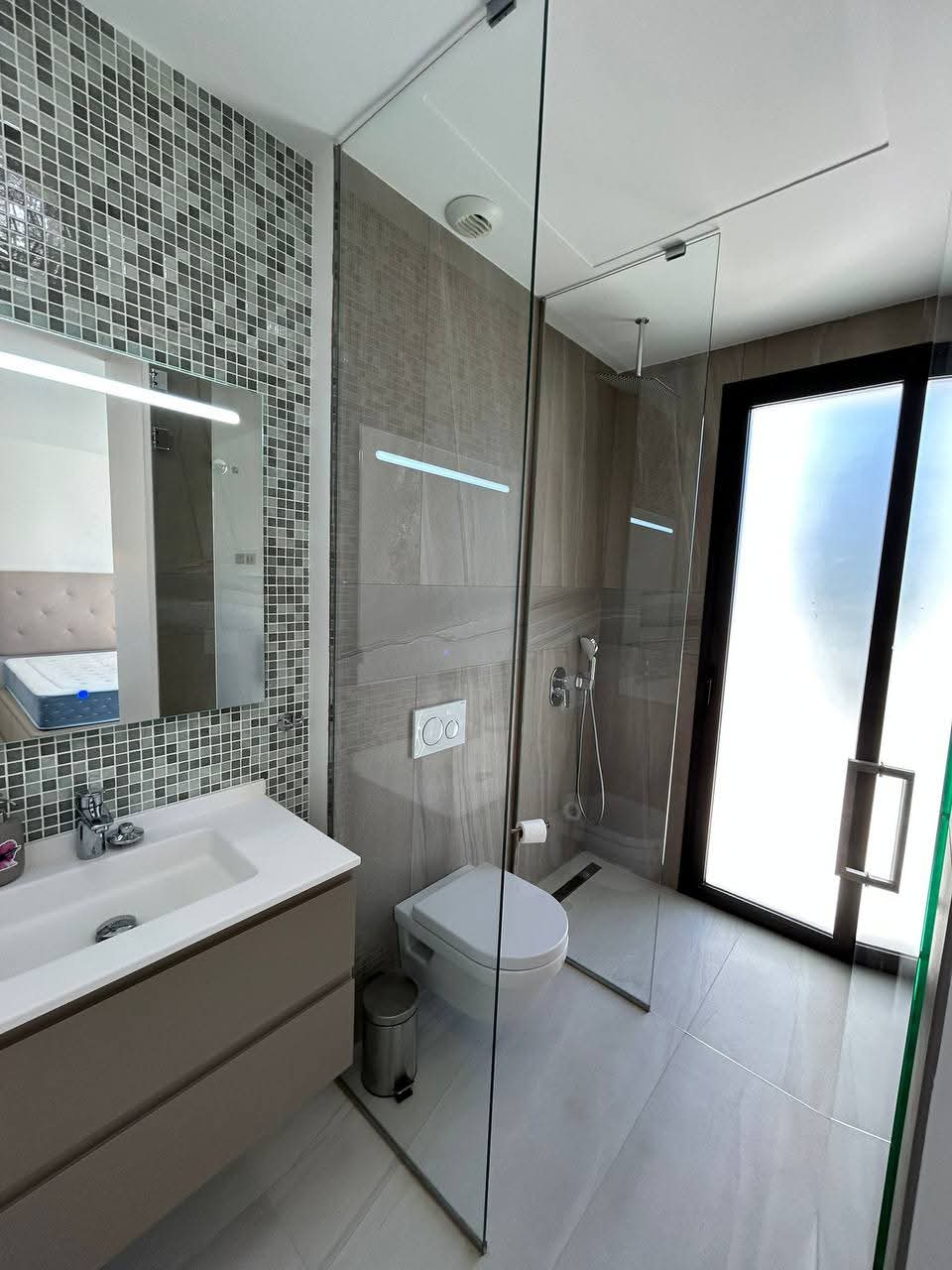 Baño moderno con ducha acristalada tras reforma realizada por empresa de reformas en Madrid